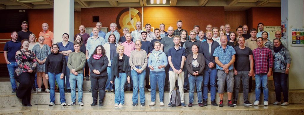 Lehrkräfte stehen in der Aula als Gruppenbild