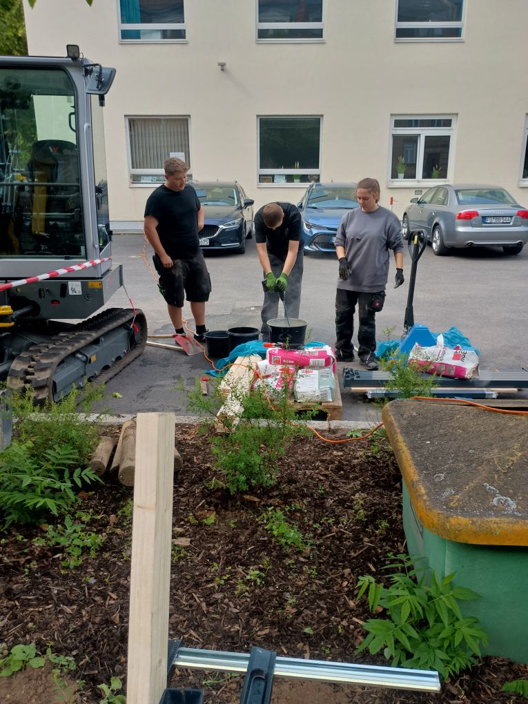3 Personen setzen das Fundament ein
